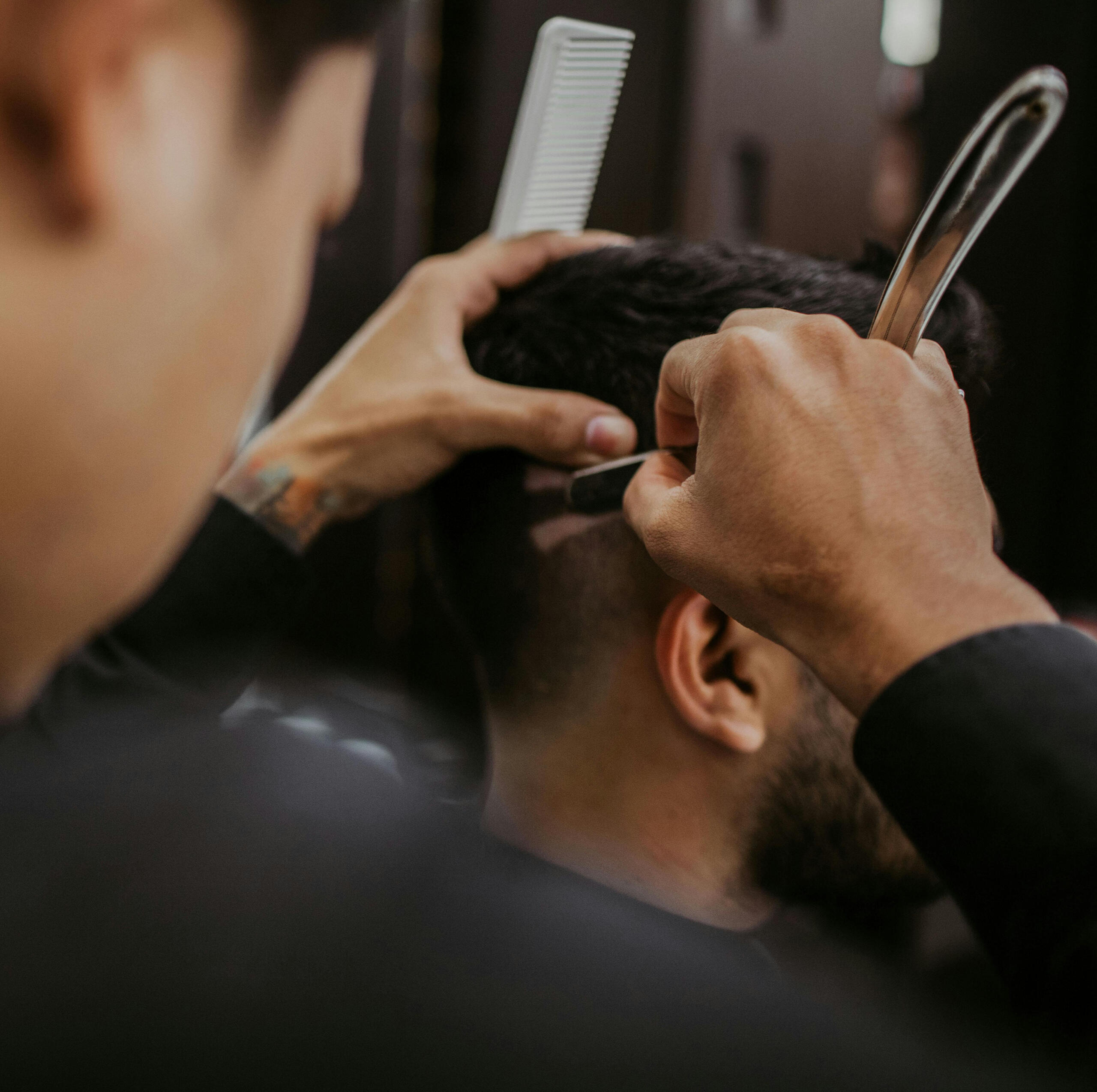 Korean barber performing a precision razor fade on a customer, showcasing modern grooming techniques.
